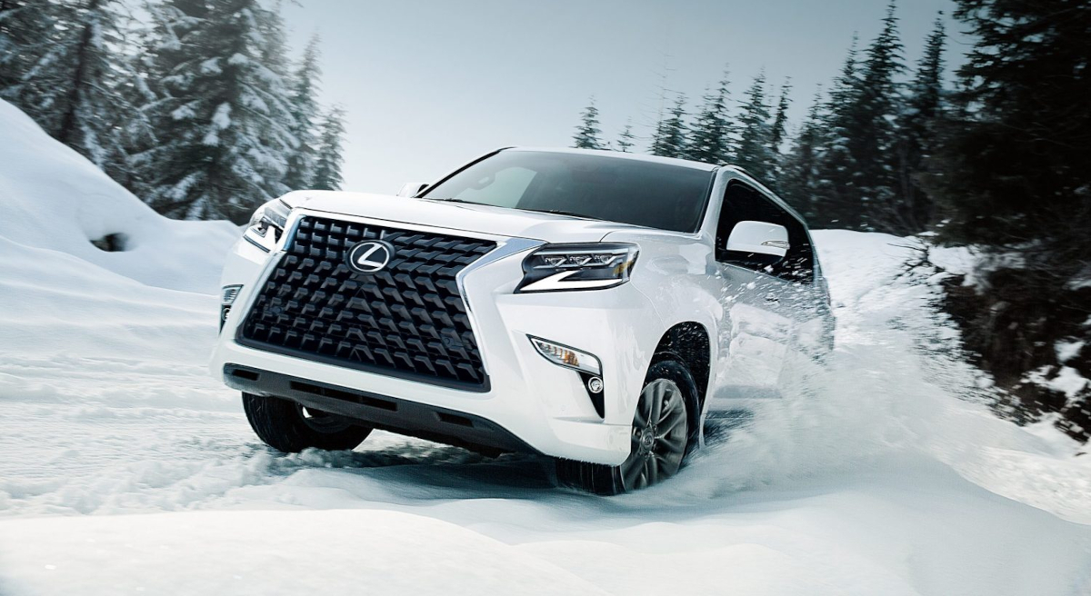 A Lexus SUV drives through the snow.