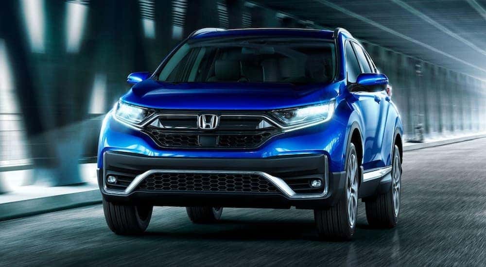 A blue 2022 Honda CR-V is shown from the front driving through a tunnel.