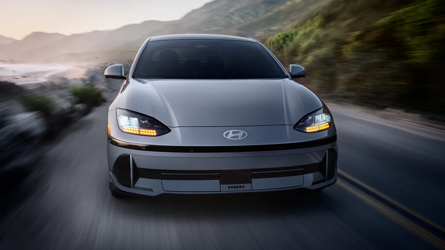 2025 Hyundai IONIQ 6 showing front of vehicle driving next to a cliff and body of water