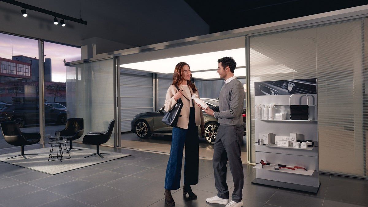 Audi dealership employee speaking with a client in the showroom