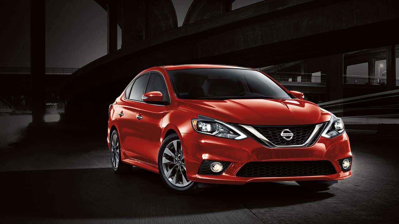 Red 2017 Nissan Sentra sedan parked under a bridge at night