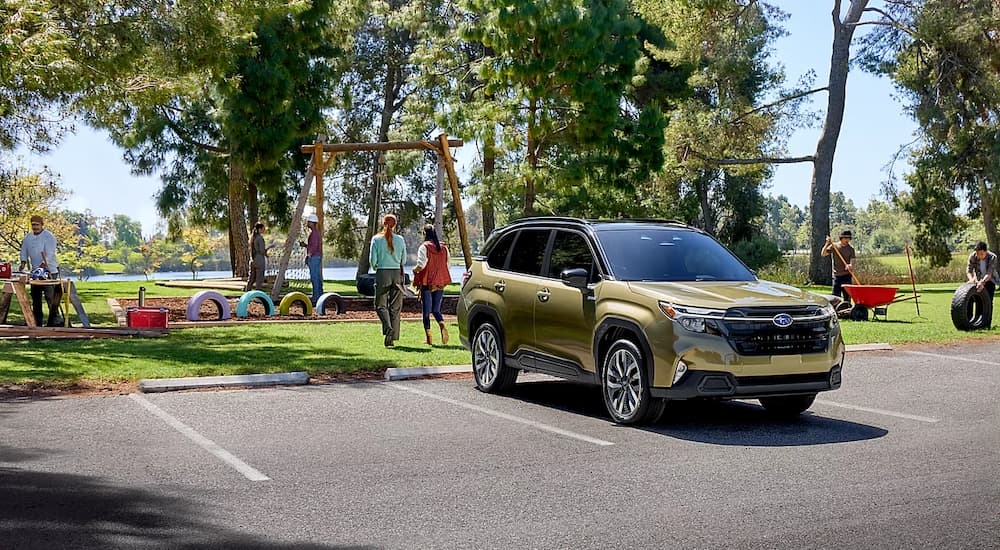 Yellow 2025 Subaru Forester parked near a park.