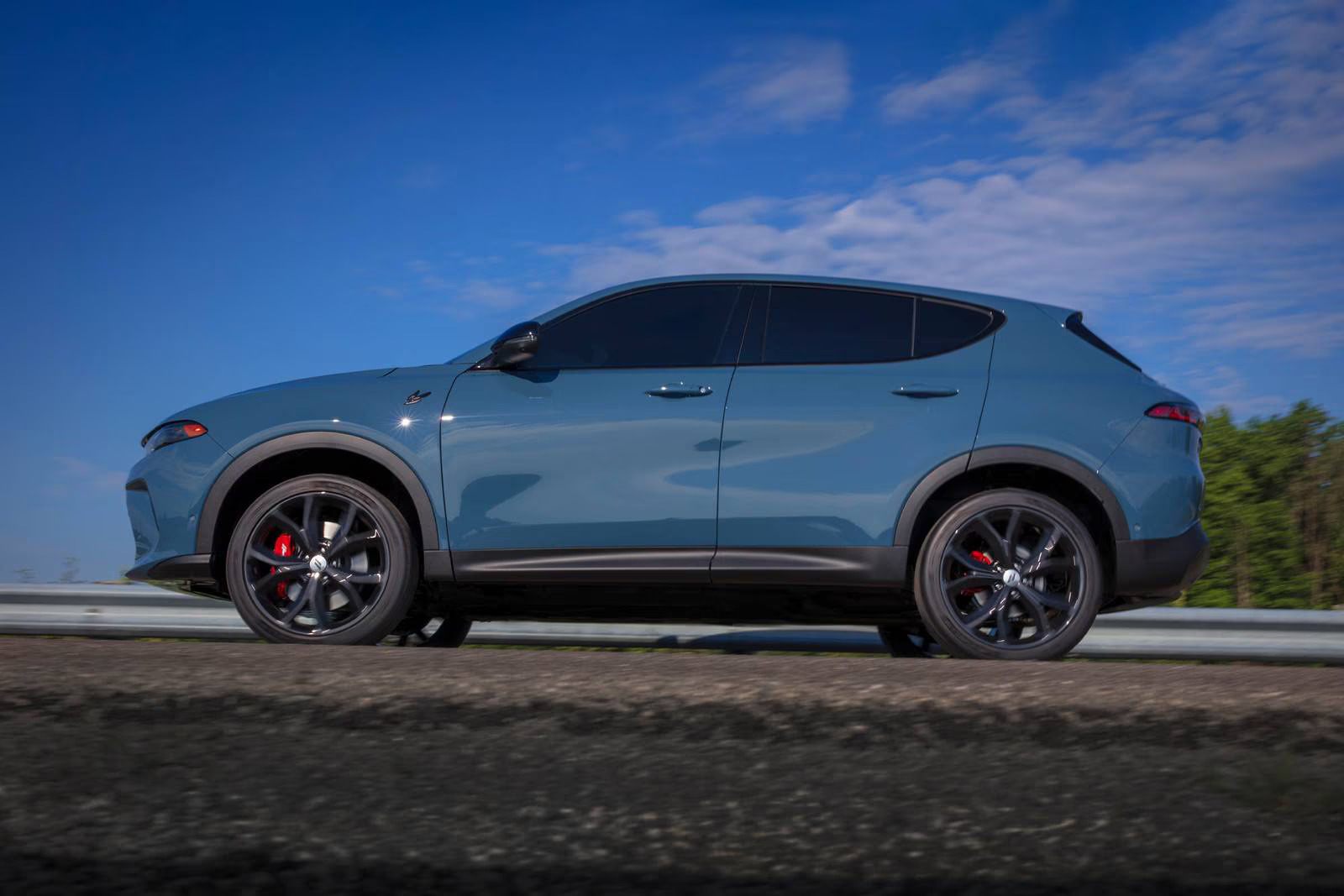 A blue car sitting in the road.