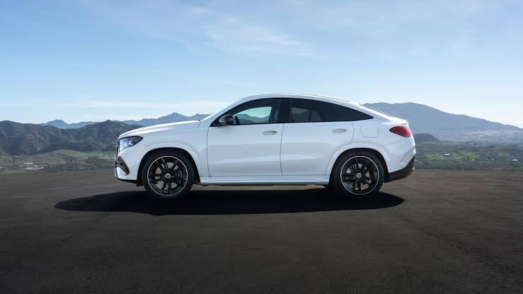 2027 Mercedes-Benz GLE Coupe in white, side profile on a mountain overlook