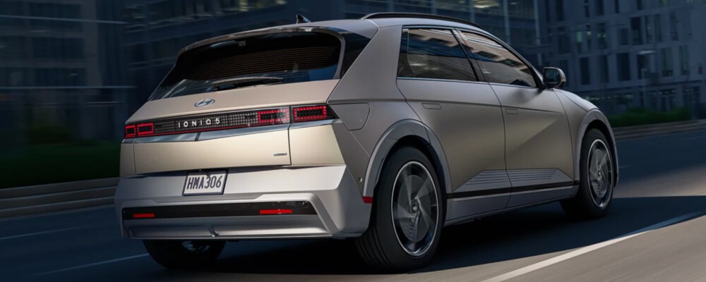 Silver 2026 Hyundai IONIQ 5 driving through the city at dusk