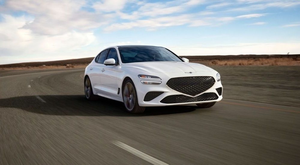 White 2025 Genesis G70 driving at an angle from the front