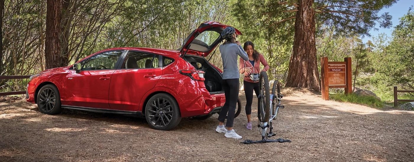 Red 2025 Subaru Impreza RS parked off-road in a forest