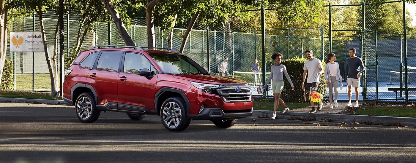 A red 2026 Subaru Forester Limited parked by a pickleball court.
