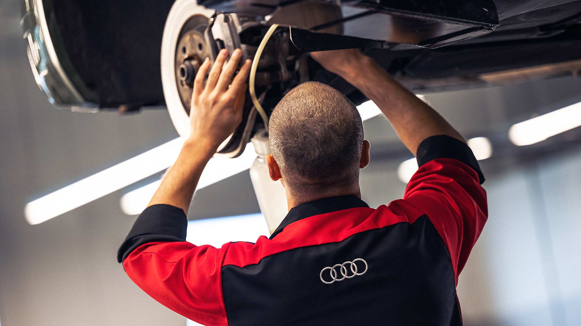 Audi service technician servicing a vehicle.
