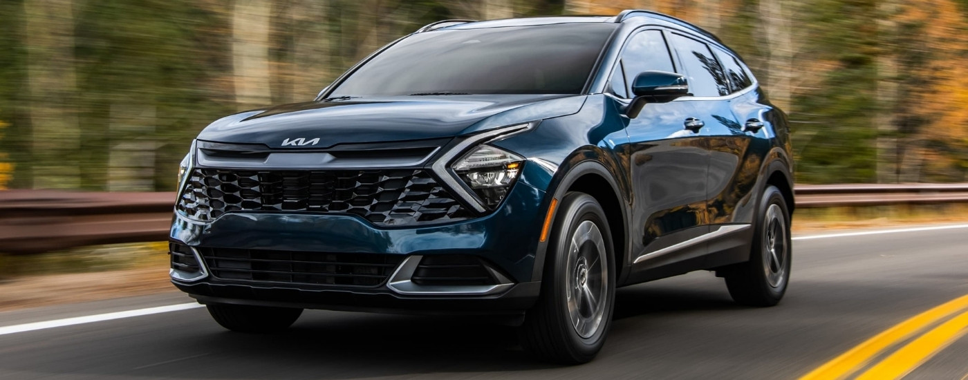 Dark blue 2023 Kia Sportage Hybrid driving to a Kia dealer near Wauwatosa