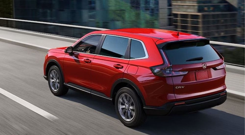 A red 2026 Honda CR-V EX shown driving over a city bridge.