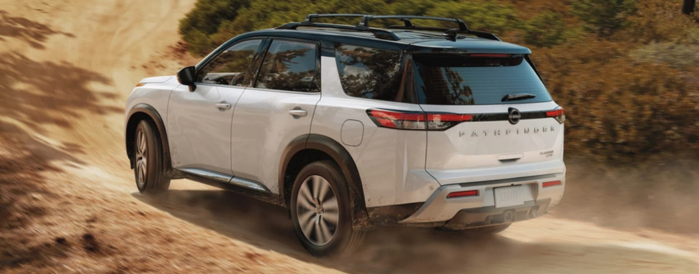 White 2023 Nissan Pathfinder driving on a dusty trail