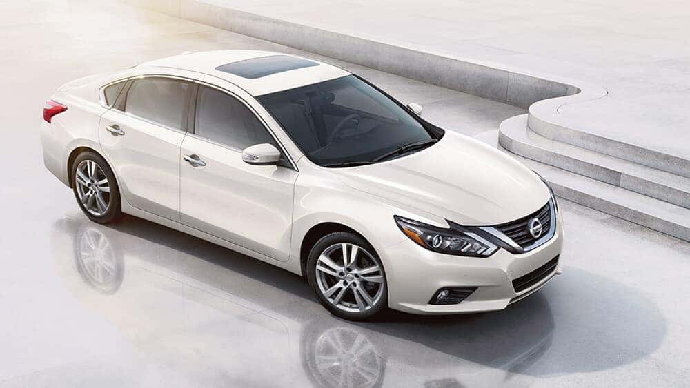 White 2017 Nissan Altima sedan with sunroof parked on a white plaza