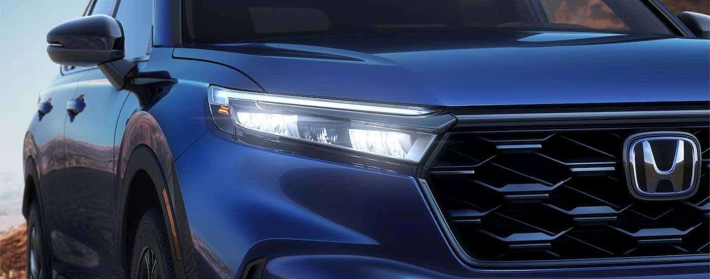 A close up of the grille of a blue 2023 Honda CR-V is shown.