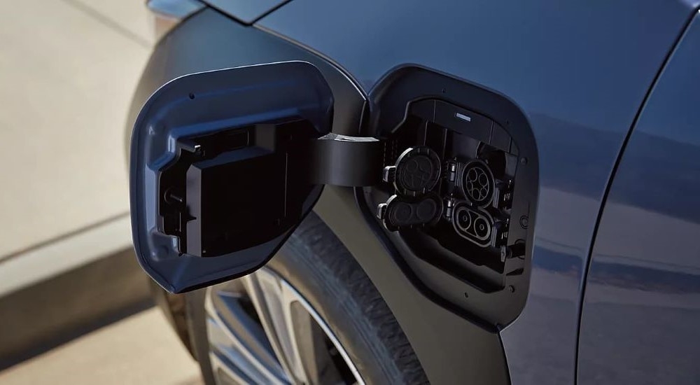 A close up shows the open charging port on a blue 2023 Subaru Solterra.
