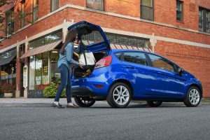 woman loading up the rear cargo area of her blue 2018 Ford Fiesta Hatchback