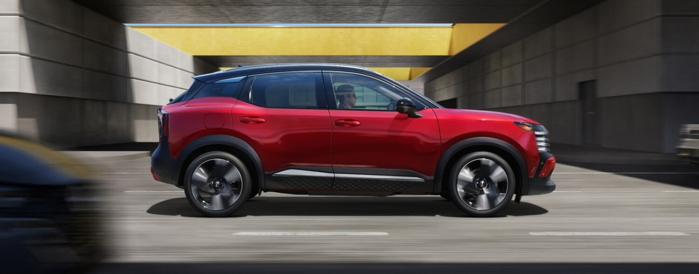 Nissan Kicks SR 2026 rojo conduciendo por una calle de la ciudad