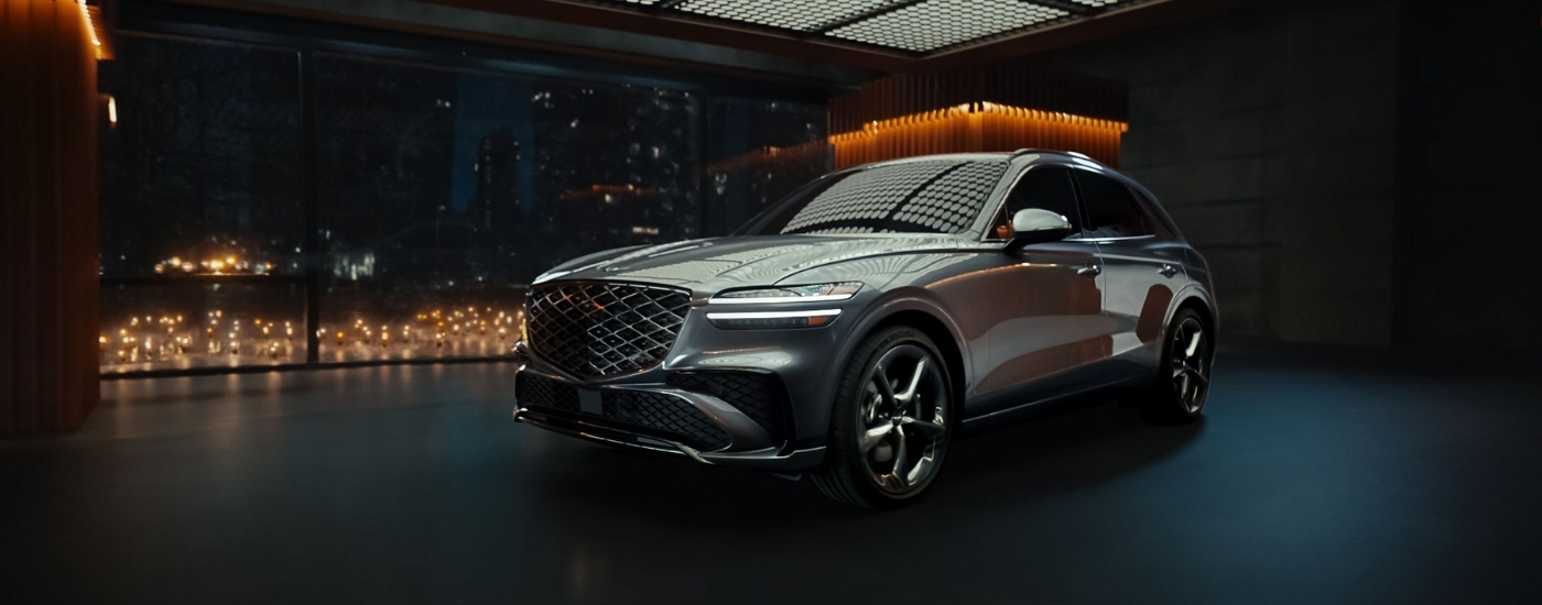 Sliver 2026 Genesis GV70 parked in a city at night