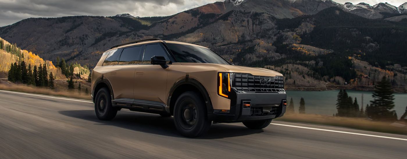 Brown  Matte 2027 Kia Telluride X-Pro SX driving on paved road.