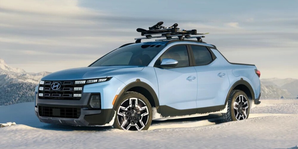Light blue 2025 Hyundai Santa Cruz with a roof rack parked in the snow