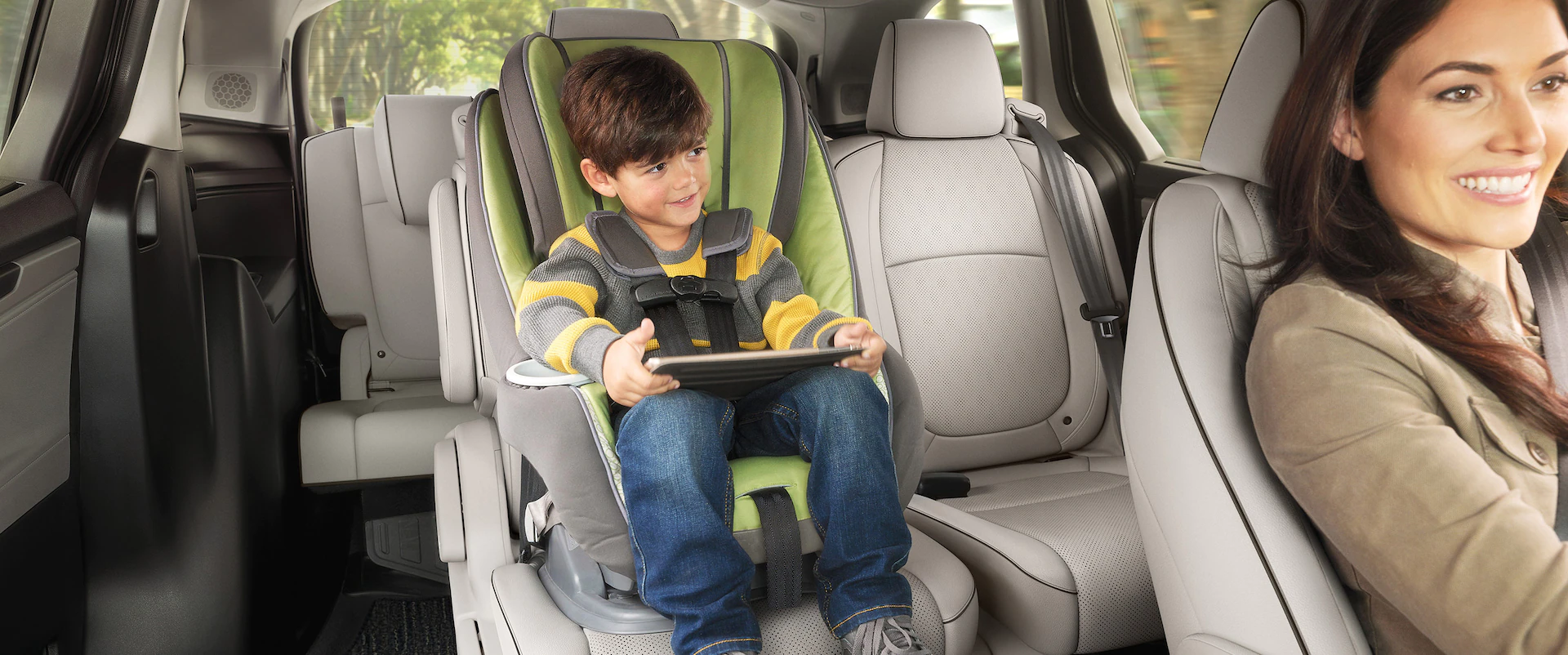 A mom and her son are shown driving in a 2023 Honda Odyssey.
