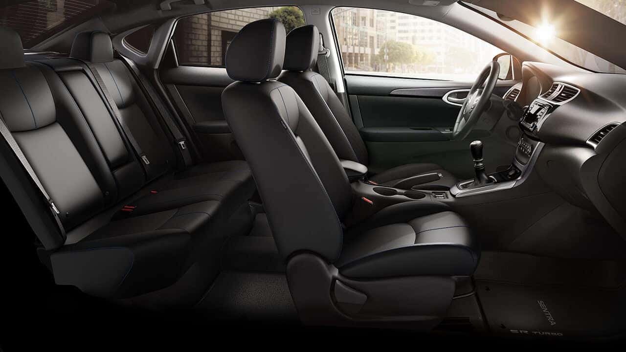 2017 Nissan Sentra black leather front and rear seats seen through the driver door