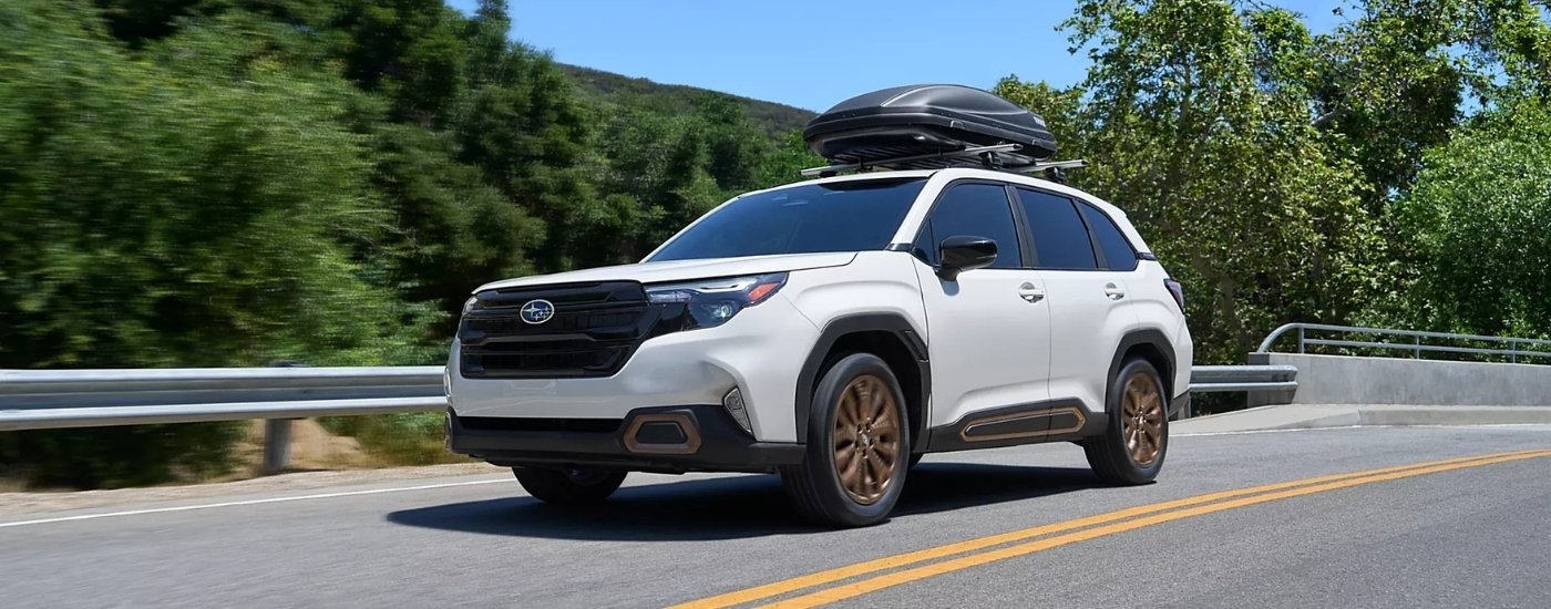 White 2026 Subaru Forester Sport driving on a highway.