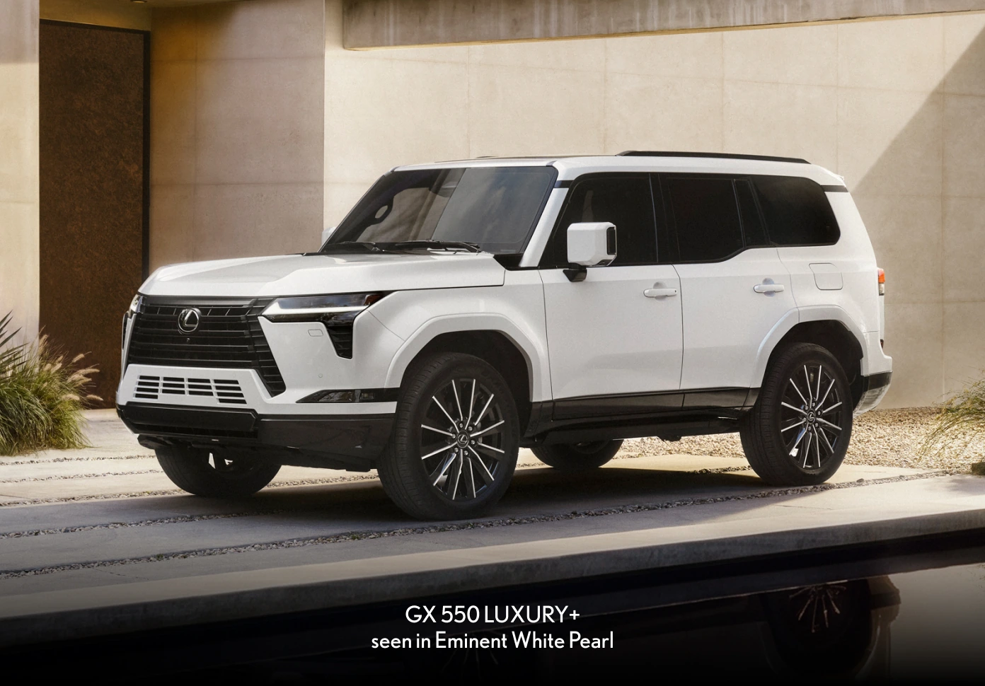 2026 Lexus GX 550 Luxury+ in Eminent White Pearl, front three-quarter view parked in a modern courtyard.