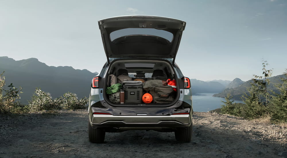 The open hatch of a blue 2026 Kia Sportage Hybrid parked off-road.