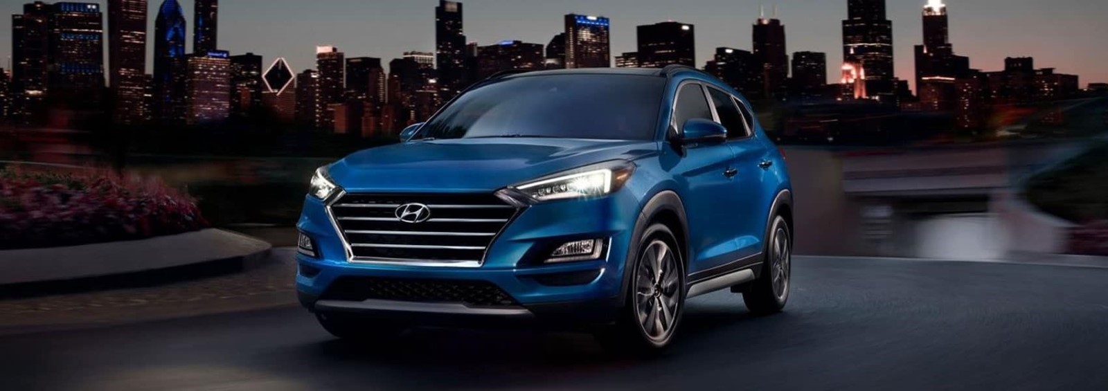 A blue 2021 Hyundai Tucson driving.