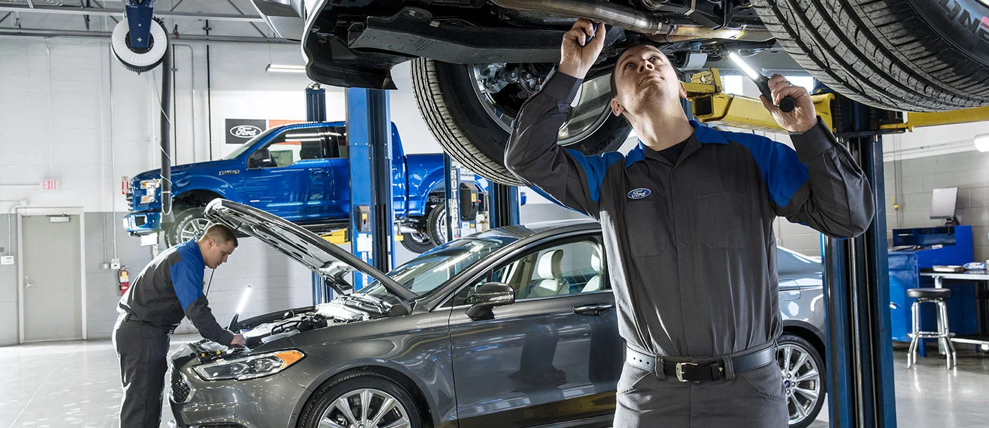 image of two ford service employees inspecting vehicles