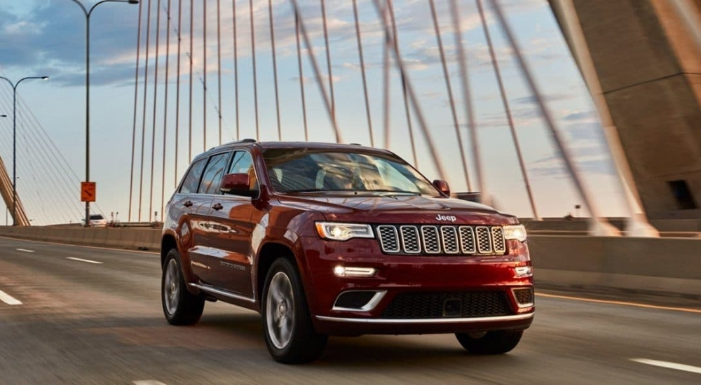 Red 2020 Jeep Grand Cherokee driving over a bridge