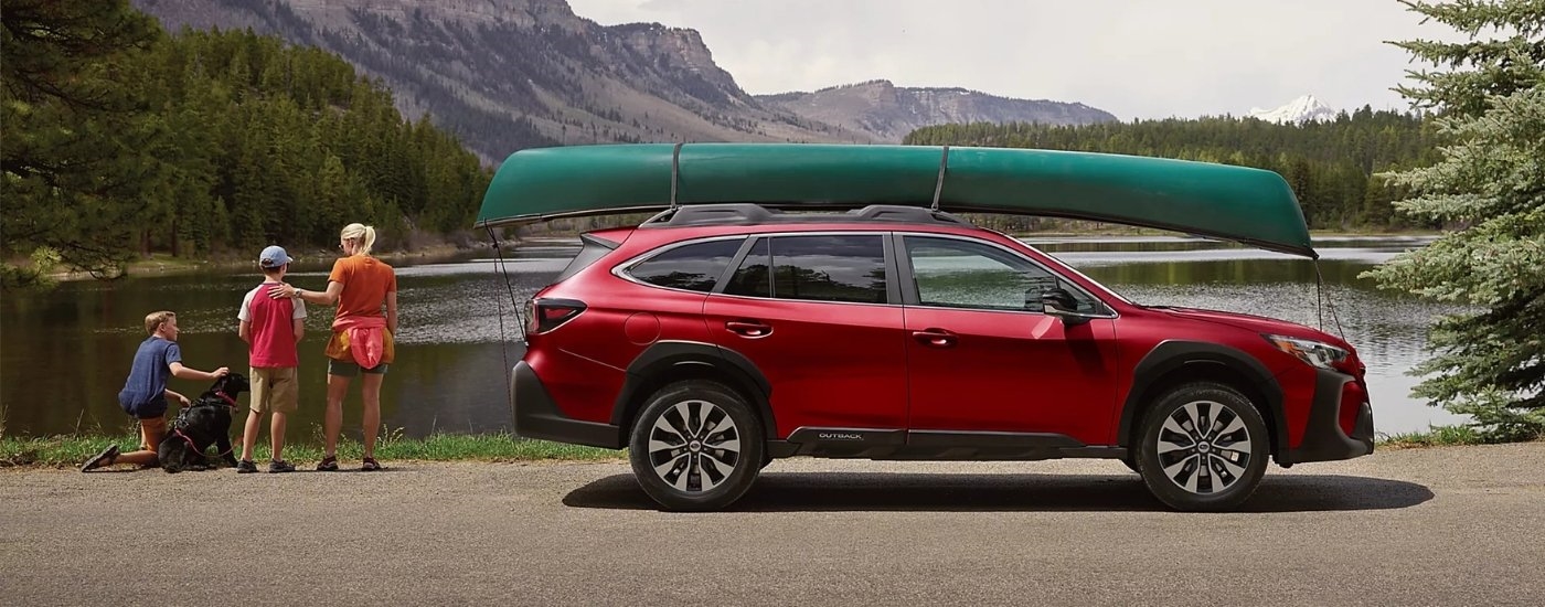 Red 2025 Subaru Outback for sale near Millbrook parked near a lake.