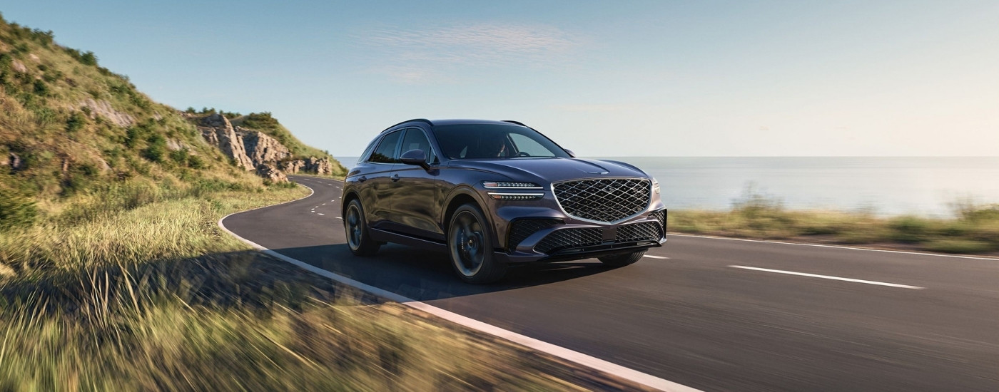 Grey 2026 Genesis GV70 for sale near Winter Garden driving on a winding road