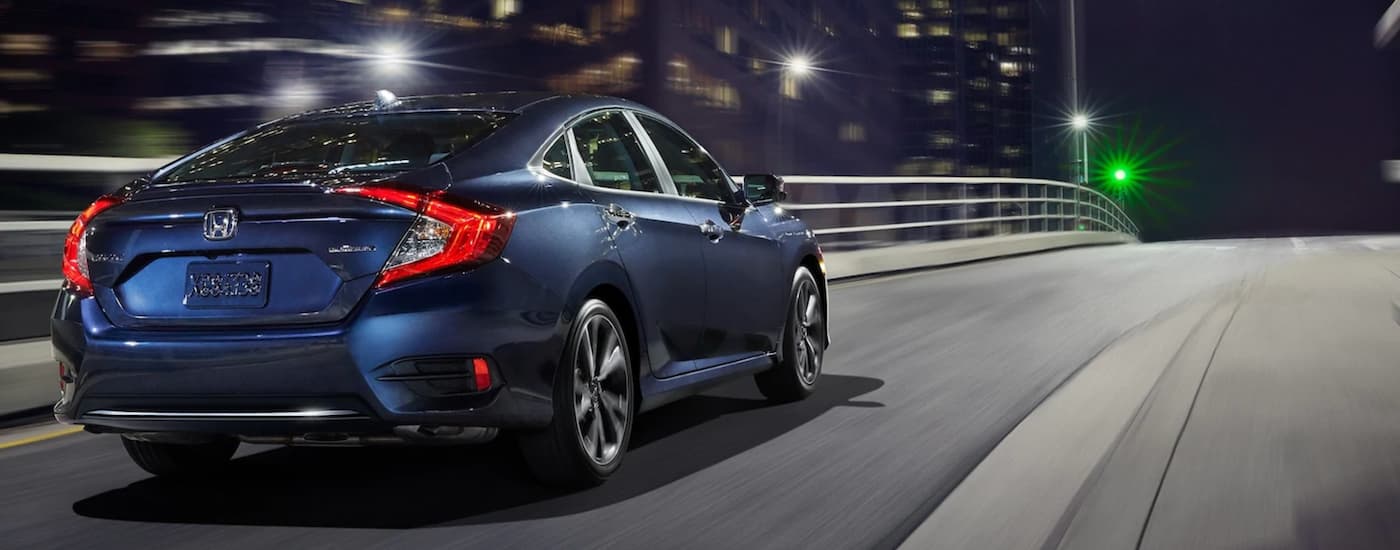 Blue 2020 Honda Civic Sedan driving on a city street at night