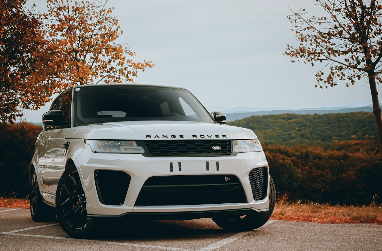 white Range Rover parked in an Autumn park