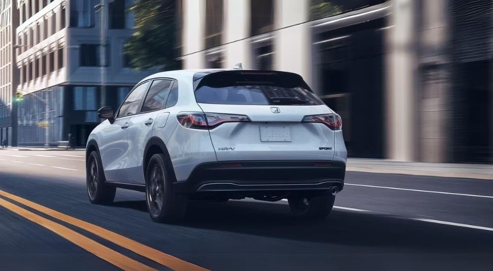 White 2023 Honda HR-V driving through a city.