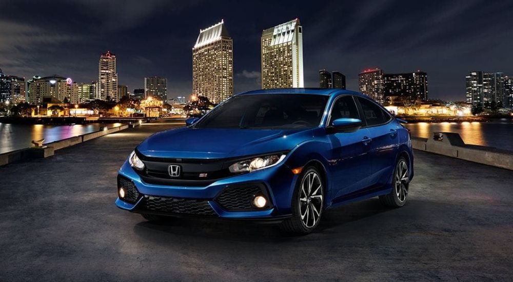 Blue 2017 Honda Civic Si parked near a city at night