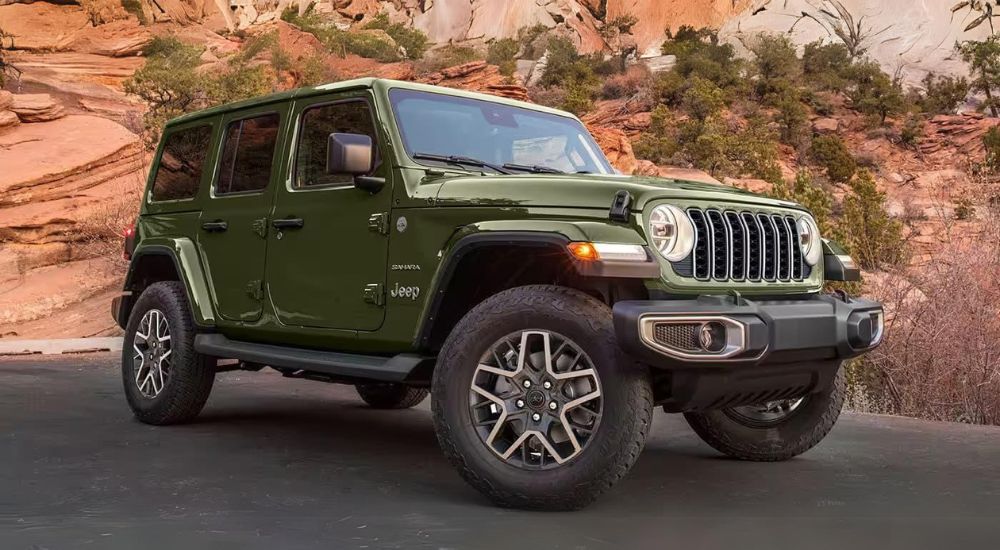 A green 2024 Jeep Wrangler Sahara Unlimited is shown parked on pavement.