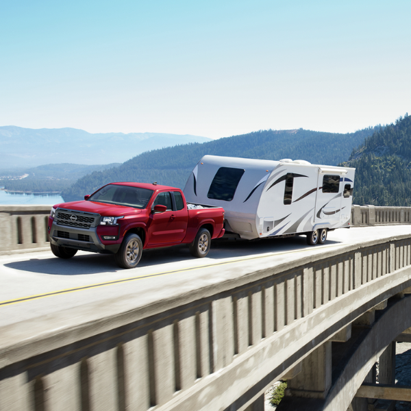 Red 2025 Nissan Frontier towing an RV