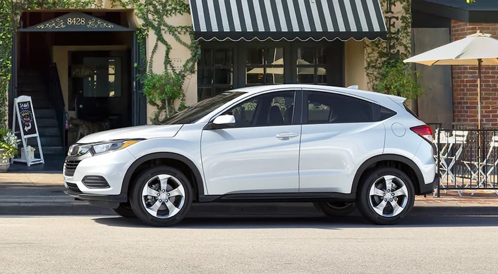 Side of a white 2020 Honda HR-V LX parked by a curb.