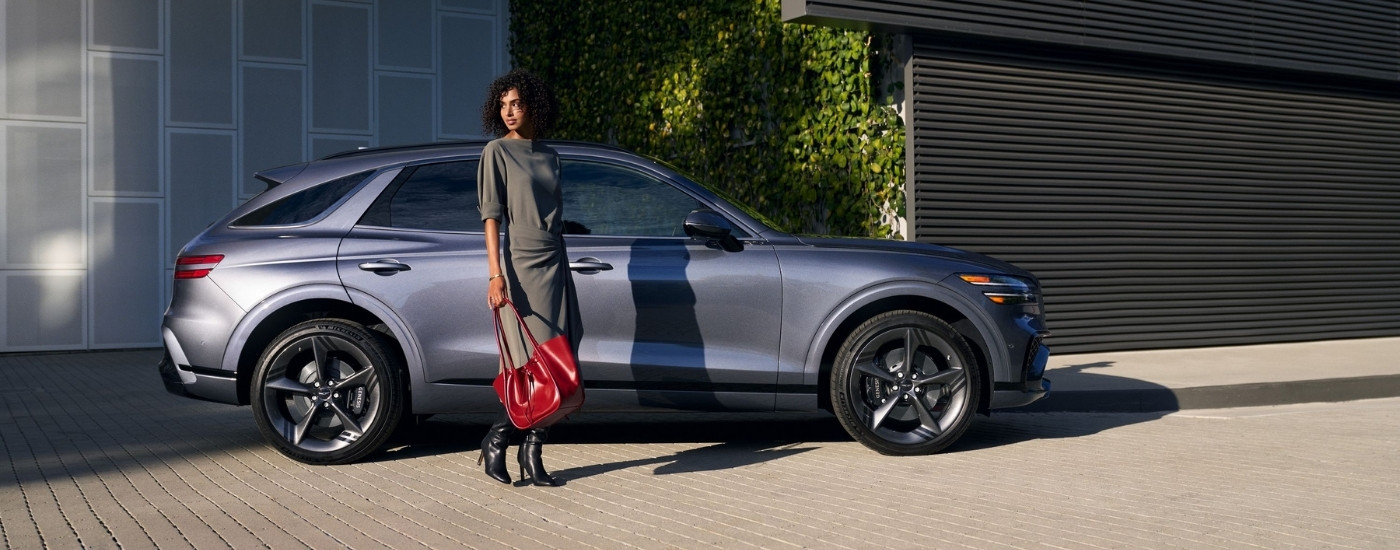 Person standing next to a grey 2027 Genesis GV70