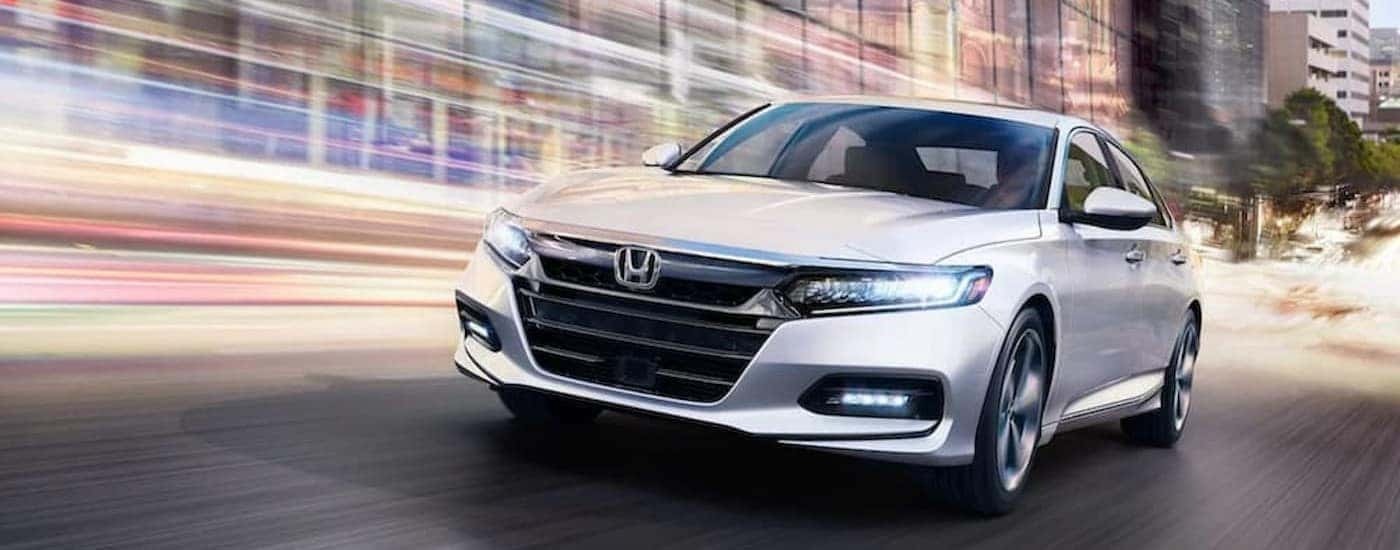 A white 2018 Honda Accord Touring is shown driving on a city street.