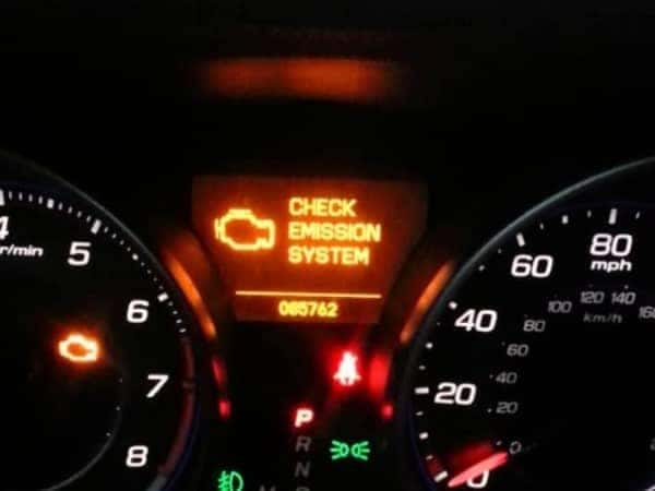 Instrument cluster with a glowing Check Emission System warning light