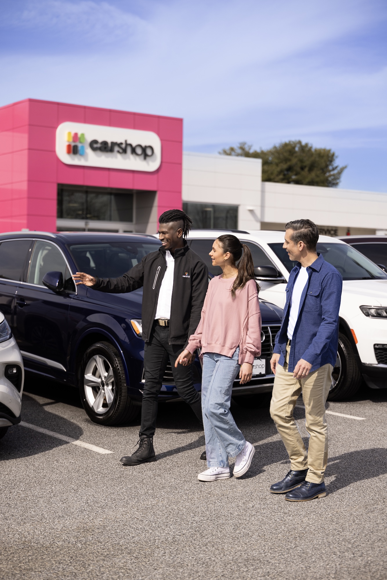 Associate showing couple vehicles in Carshop lot