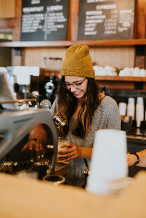 Barista at a Kirksville, MO coffee shop serving a latte.