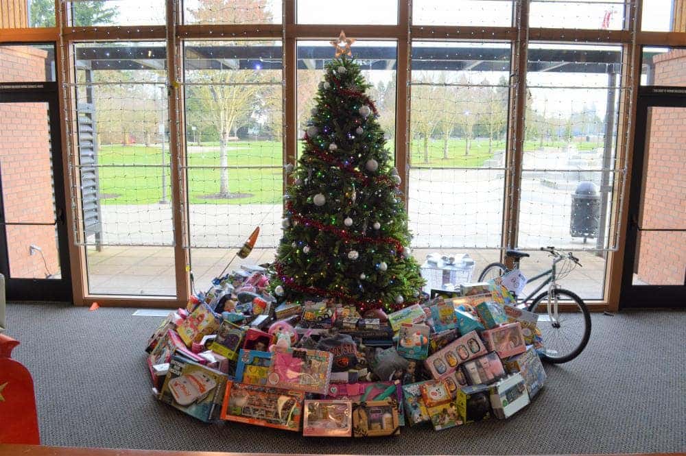 Donated toys and a bike under a Christmas tree