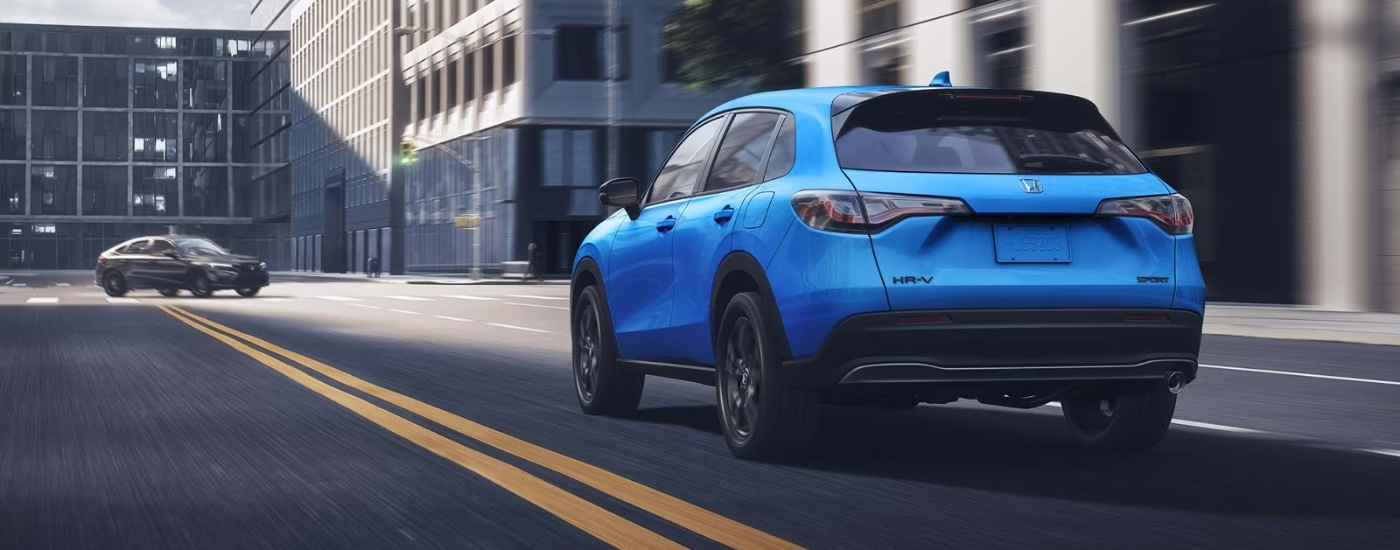 Blue 2027 Honda HR-V Sport driving on a city street