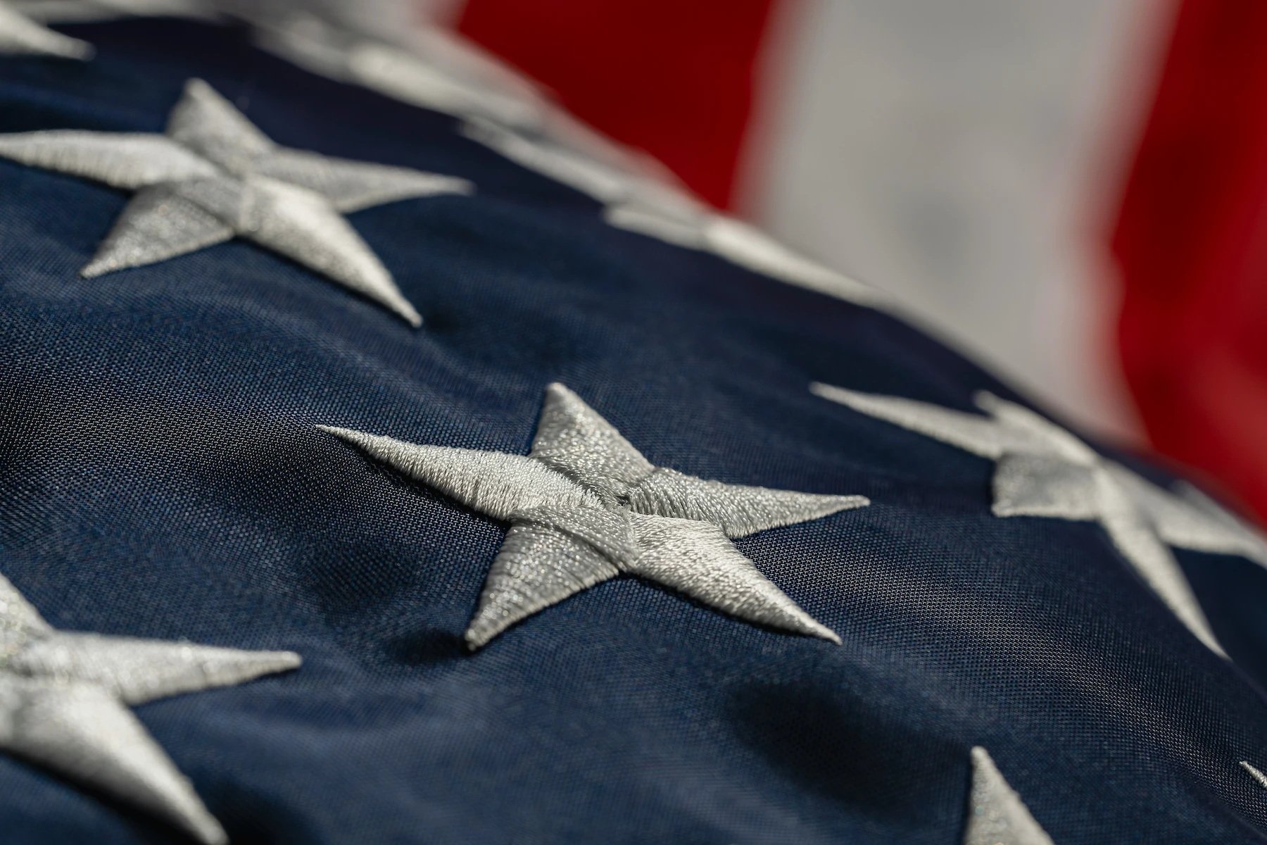 Close-up of an embroidered American flag’s stars and stripes, illustrating the Kia Military Rebate Program.
