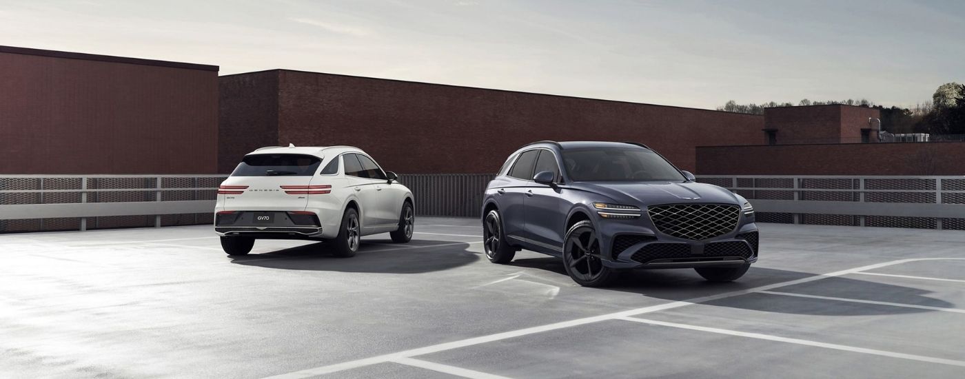 A white and a blue 2026 Genesis GV70 parked on a rooftop lot